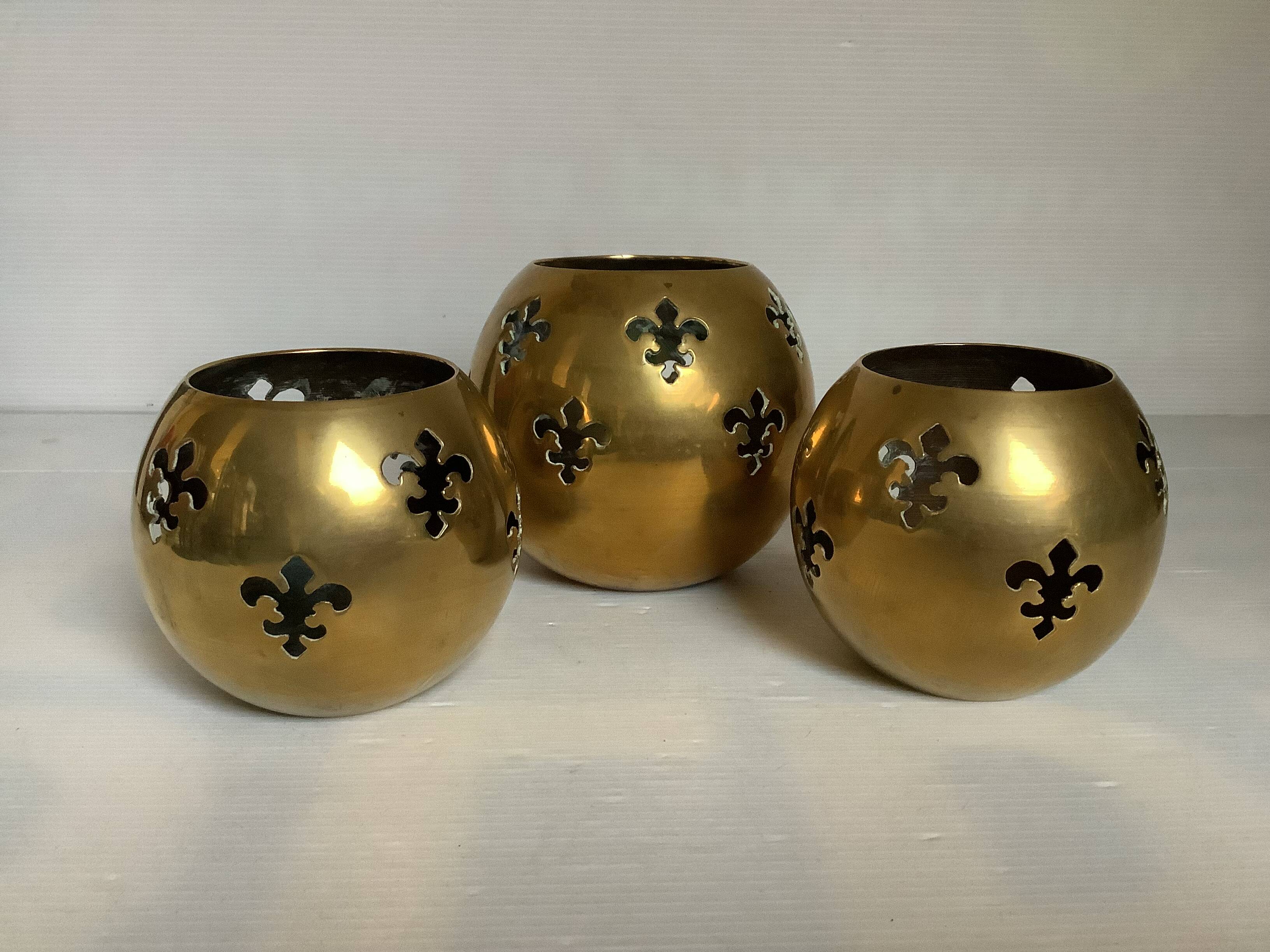 Trio of brass fleur-de-lis candle holders