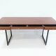 Wooden desk with drawers and black lacquered legs.