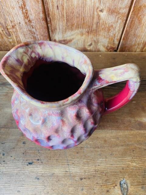Old pitcher in burgundy ceramic
