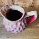 Old pitcher in burgundy ceramic
