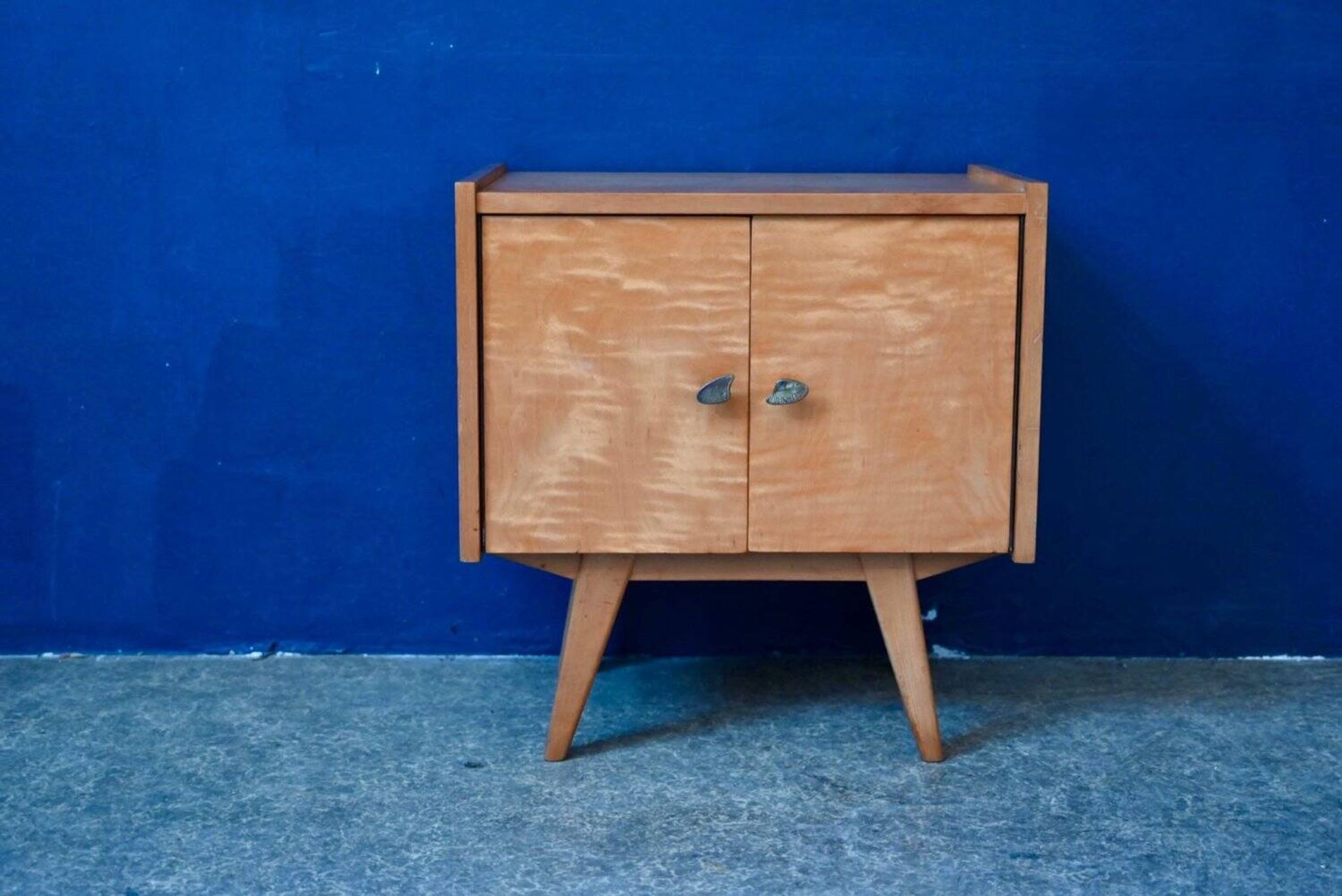 Rockabilly design bedside table with tapered legs.