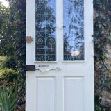 Entrance door in solid oak, cast iron grille, 1930s