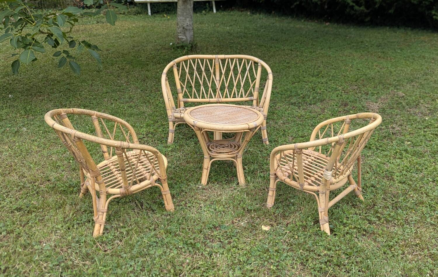 Set of children's rattan garden furniture from the 1950s and 1960s, including chairs, table, and bench.