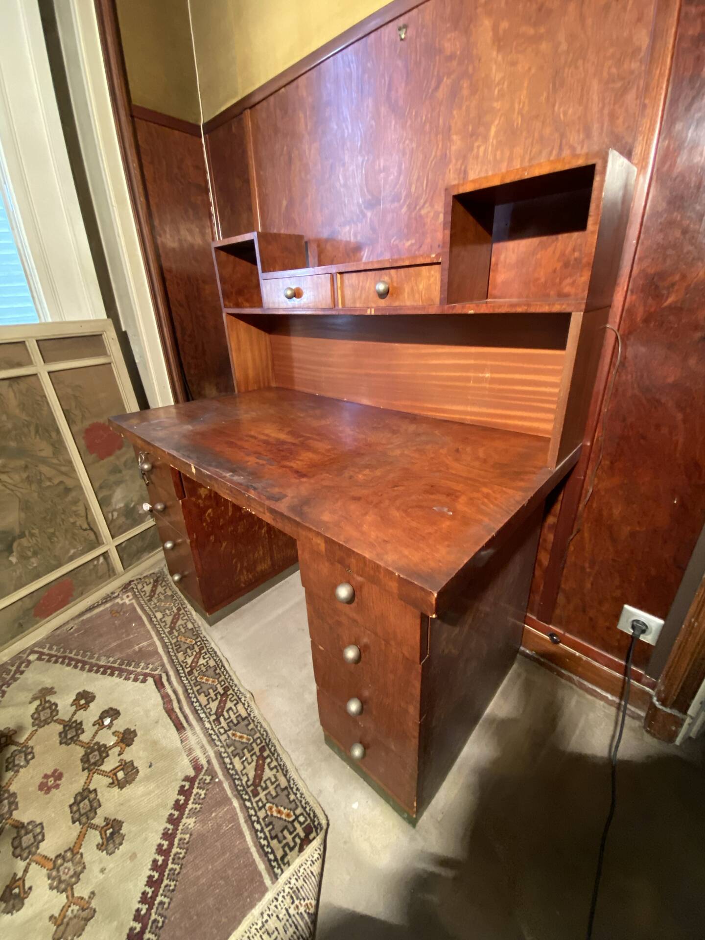 Vintage desk with drawers and a hutch with numerous drawers.