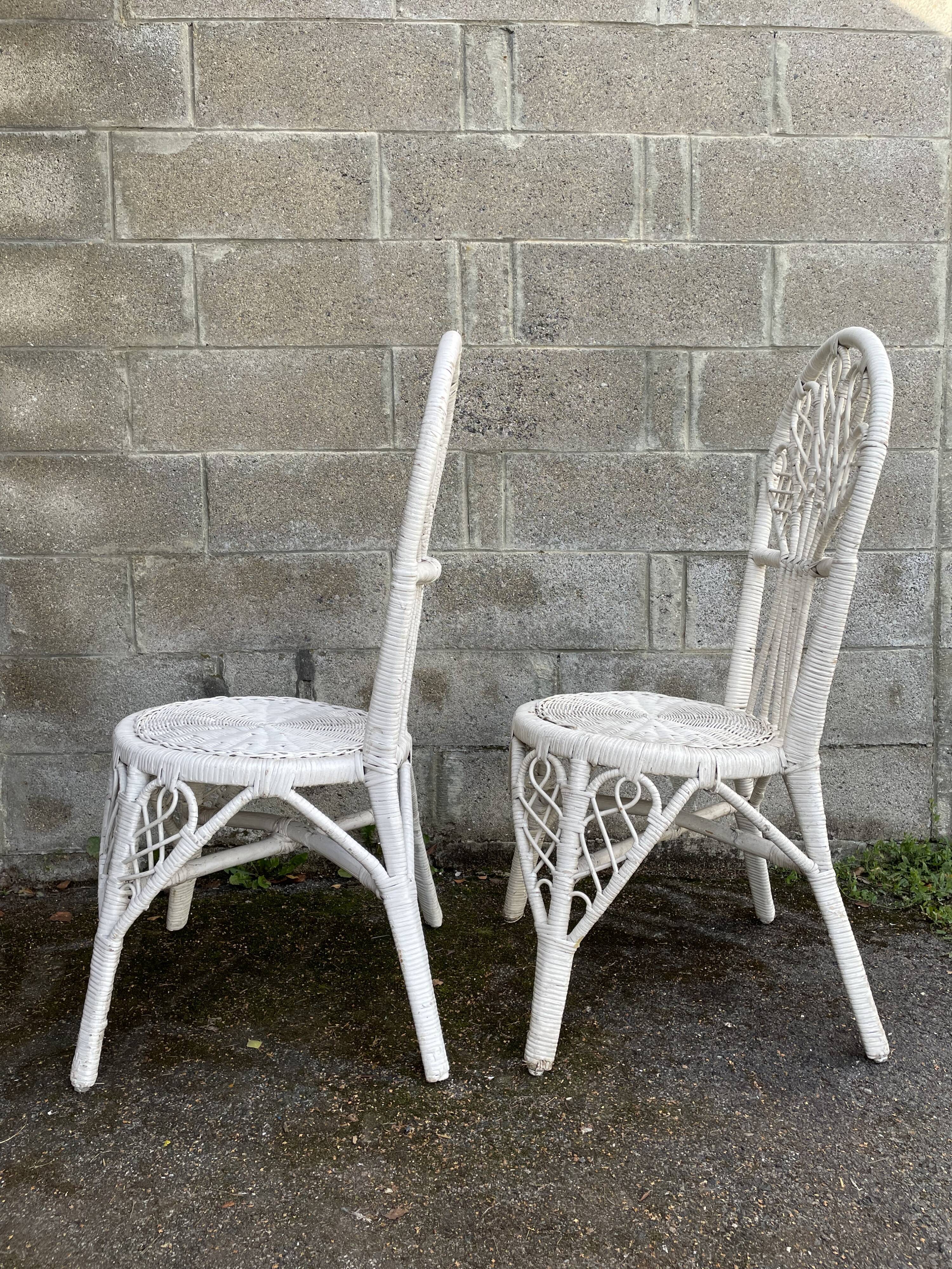Pair of white peacock rattan chairs, circa 1960