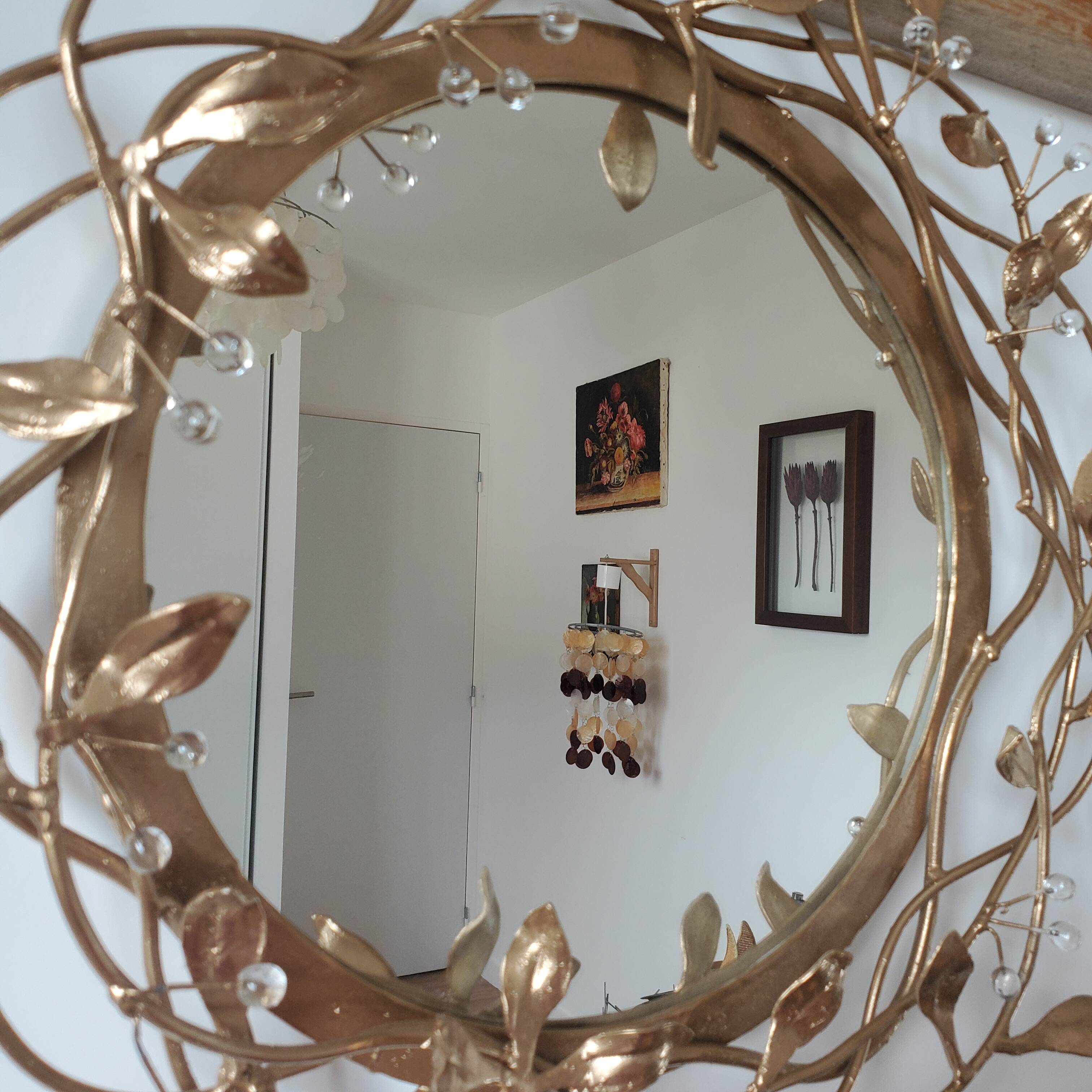Round mirror in gilded wrought iron and leaves