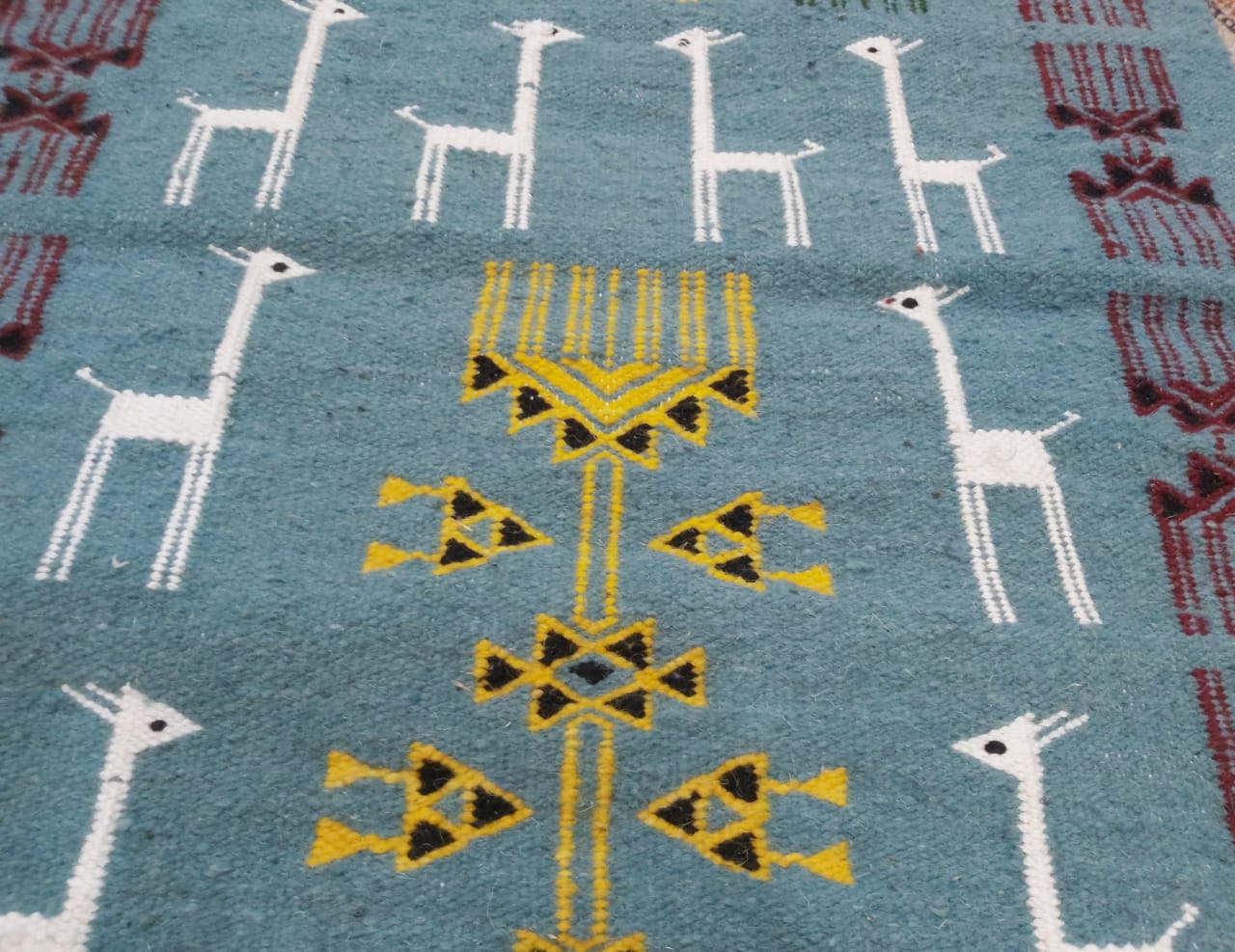 Blue carpet with gazelle patterns woven by hand