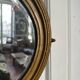 Antique oval mirror in gilded wood, bevelled mercury glass, 19th century.