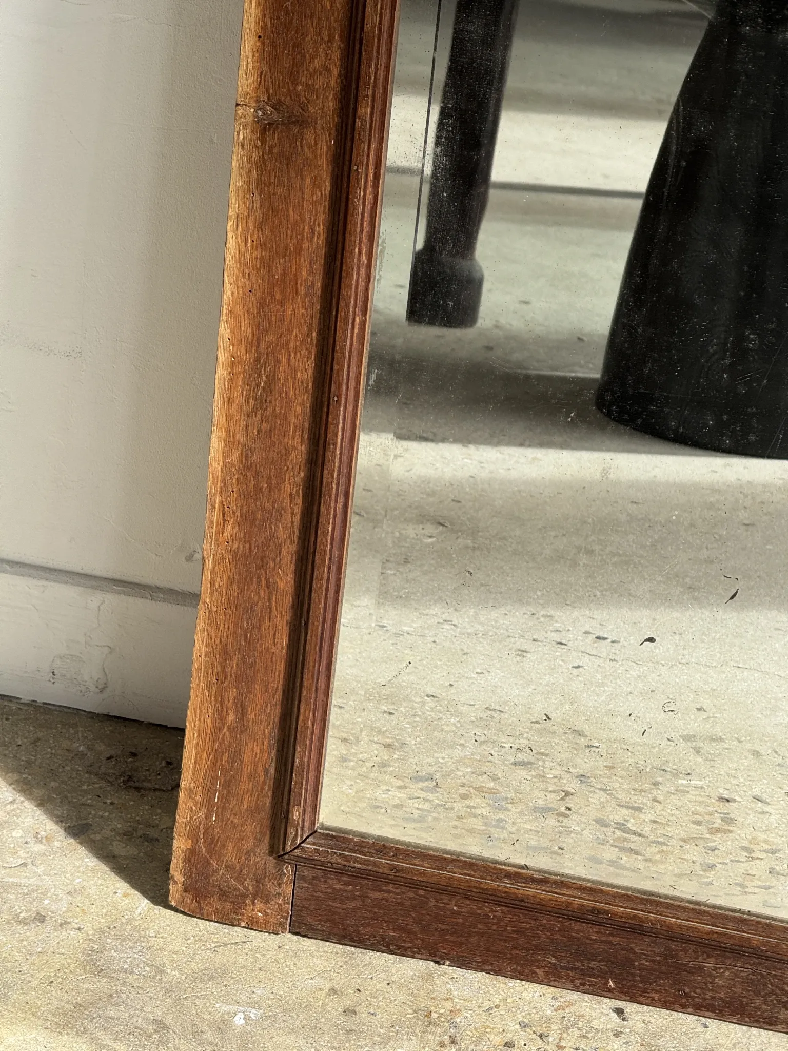 Antique mirror door (left) of a brown oak wardrobe with bevelled glass.