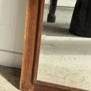 Antique mirror door (left) of a brown oak wardrobe with bevelled glass.