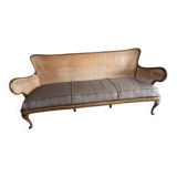 Sofa with backrest and cane armrests