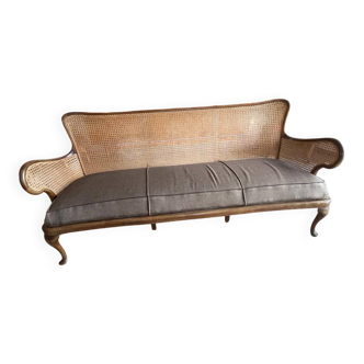 Sofa with backrest and cane armrests