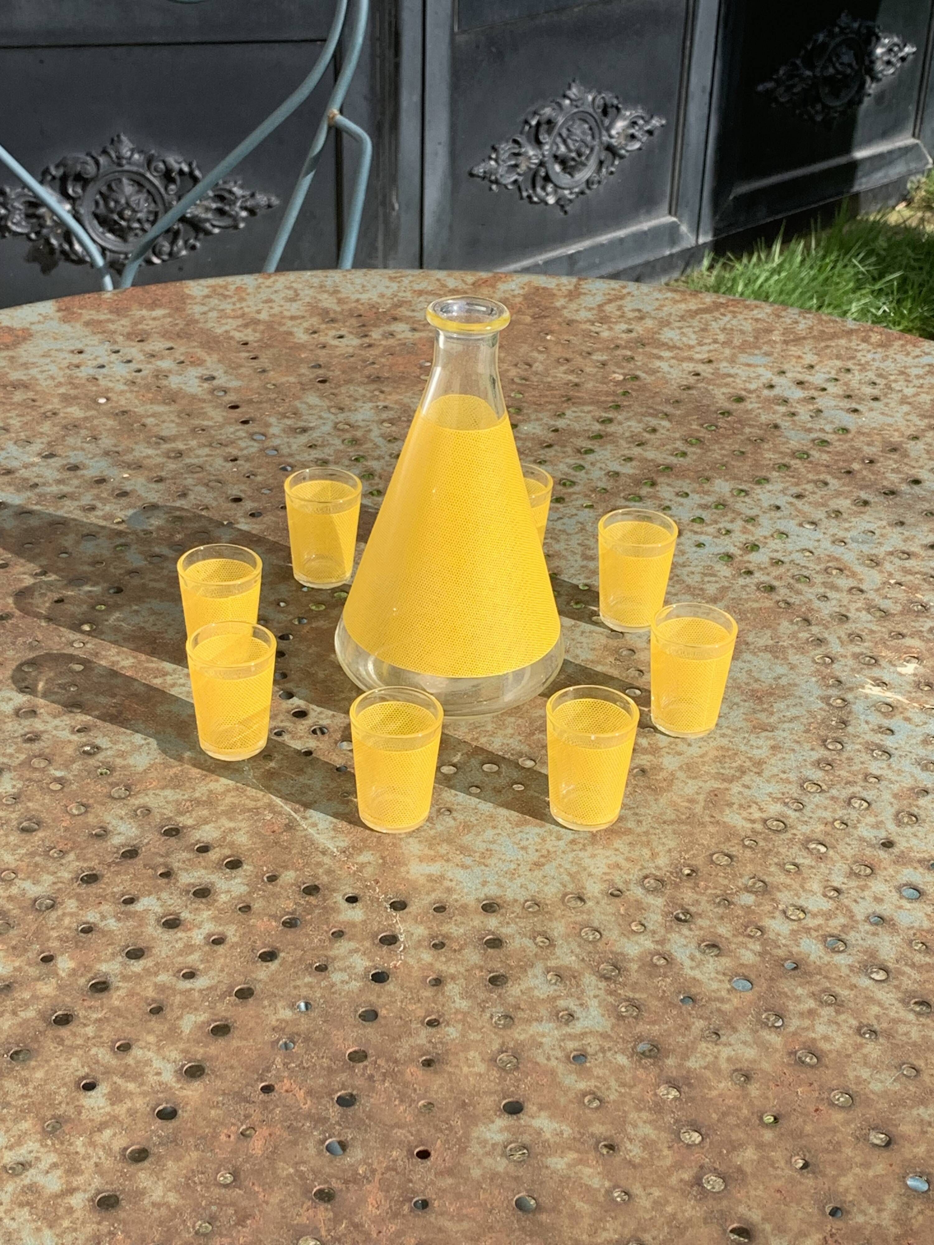 Liqueur service composed of a glass carafe and 8 small yellow screen-printed glasses