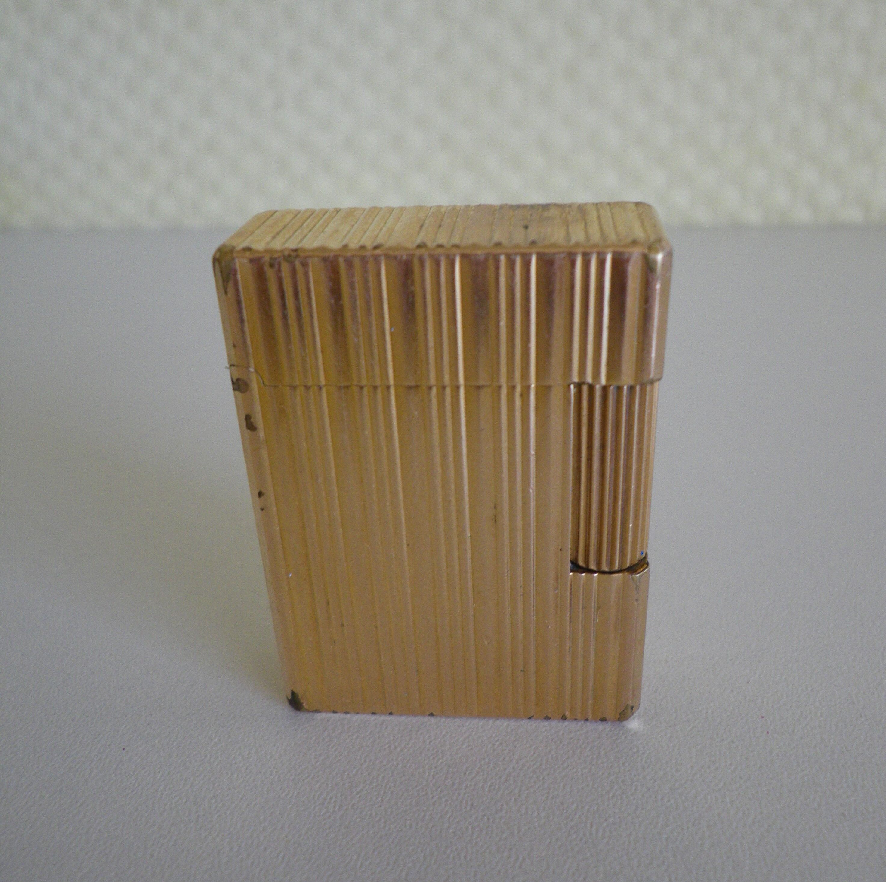 2 st dupont lighters, gold plated, punches, numbered, 1 striated pattern, 1 hammered pattern, 70s