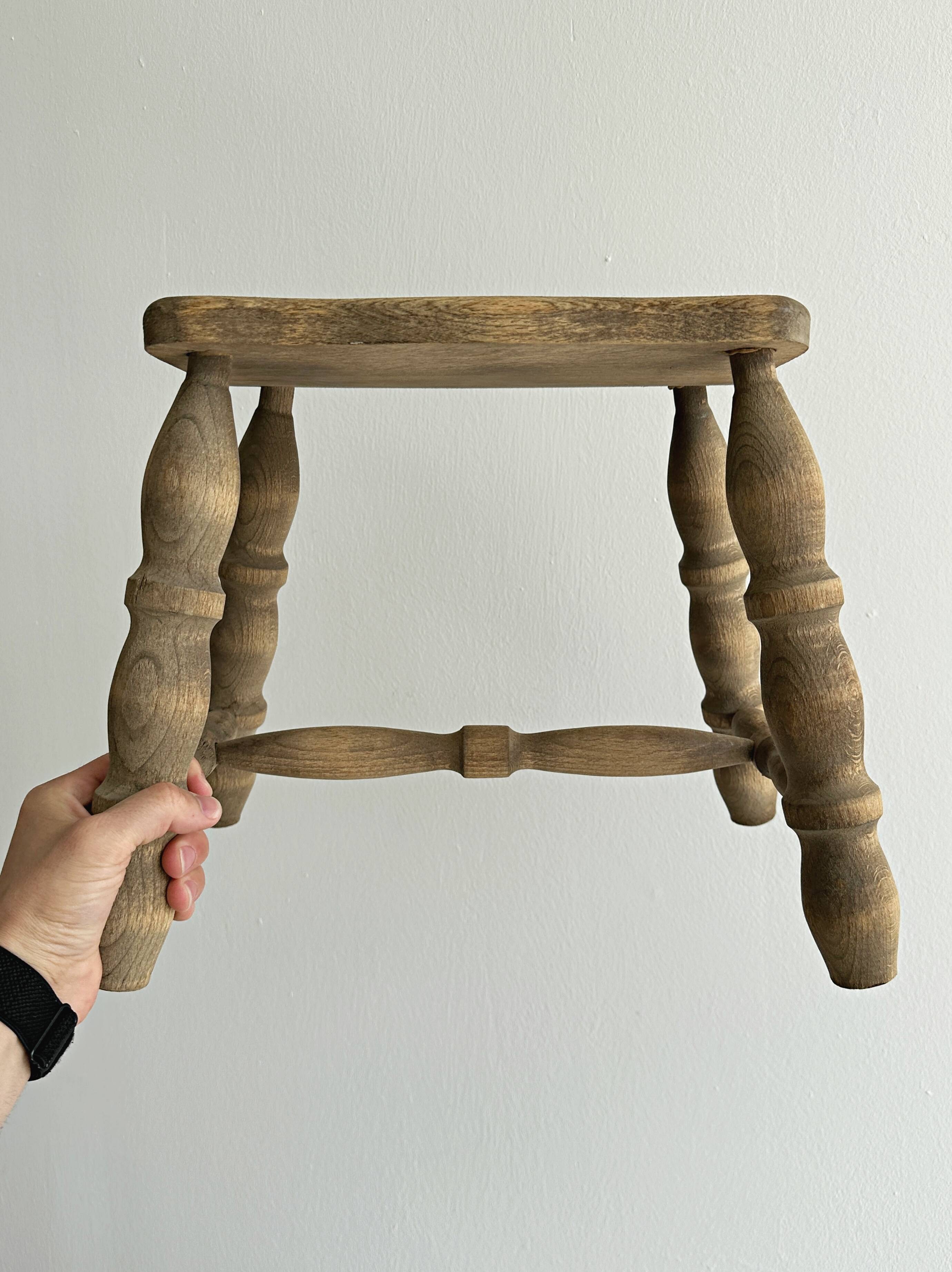 Antique wooden stool with four turned legs.