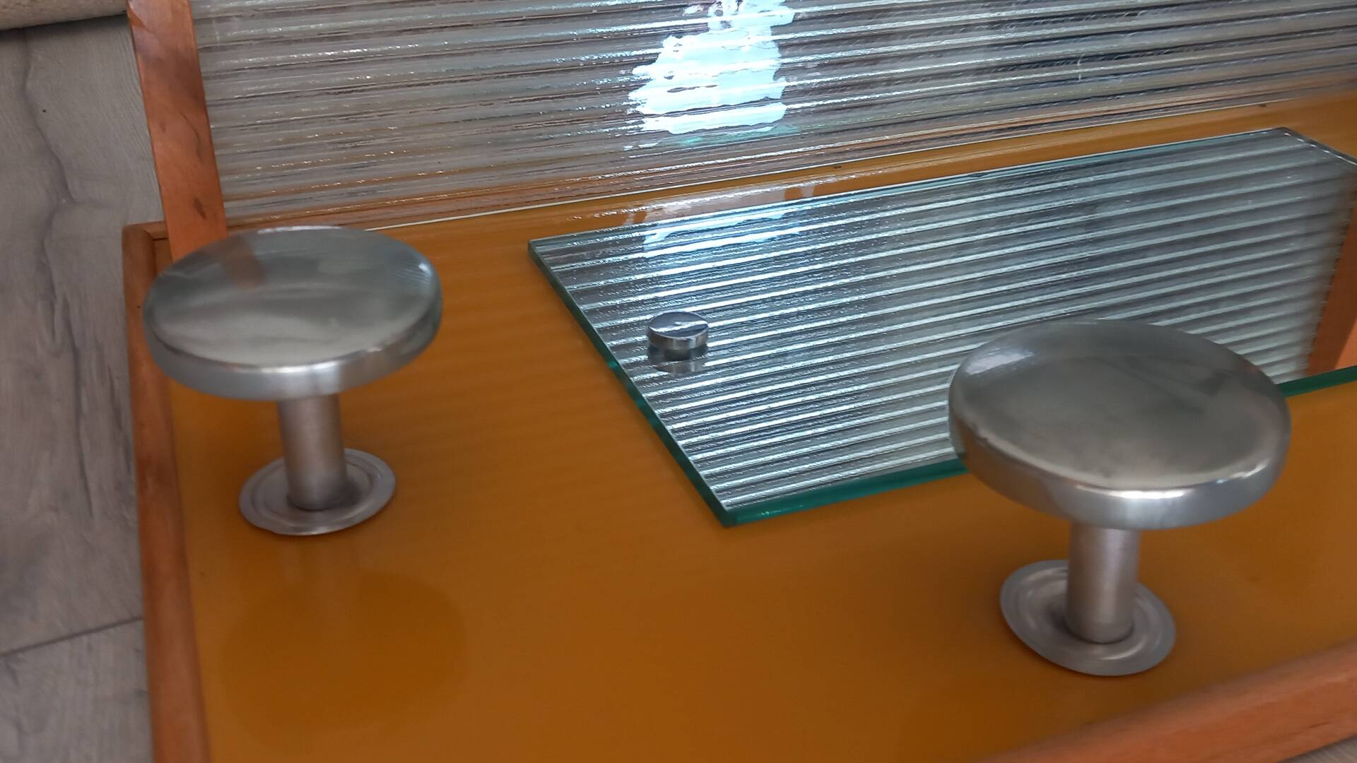 1950s coat rack with mirror, metal hooks, and glass shelf.
