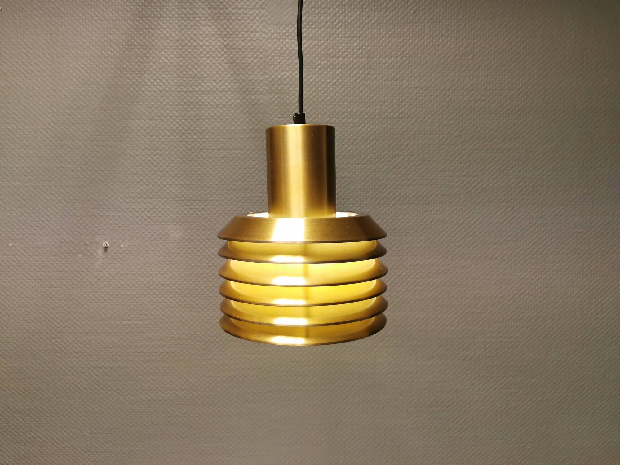 Hanging lamp in gold-colored aluminum with many layers of shades.