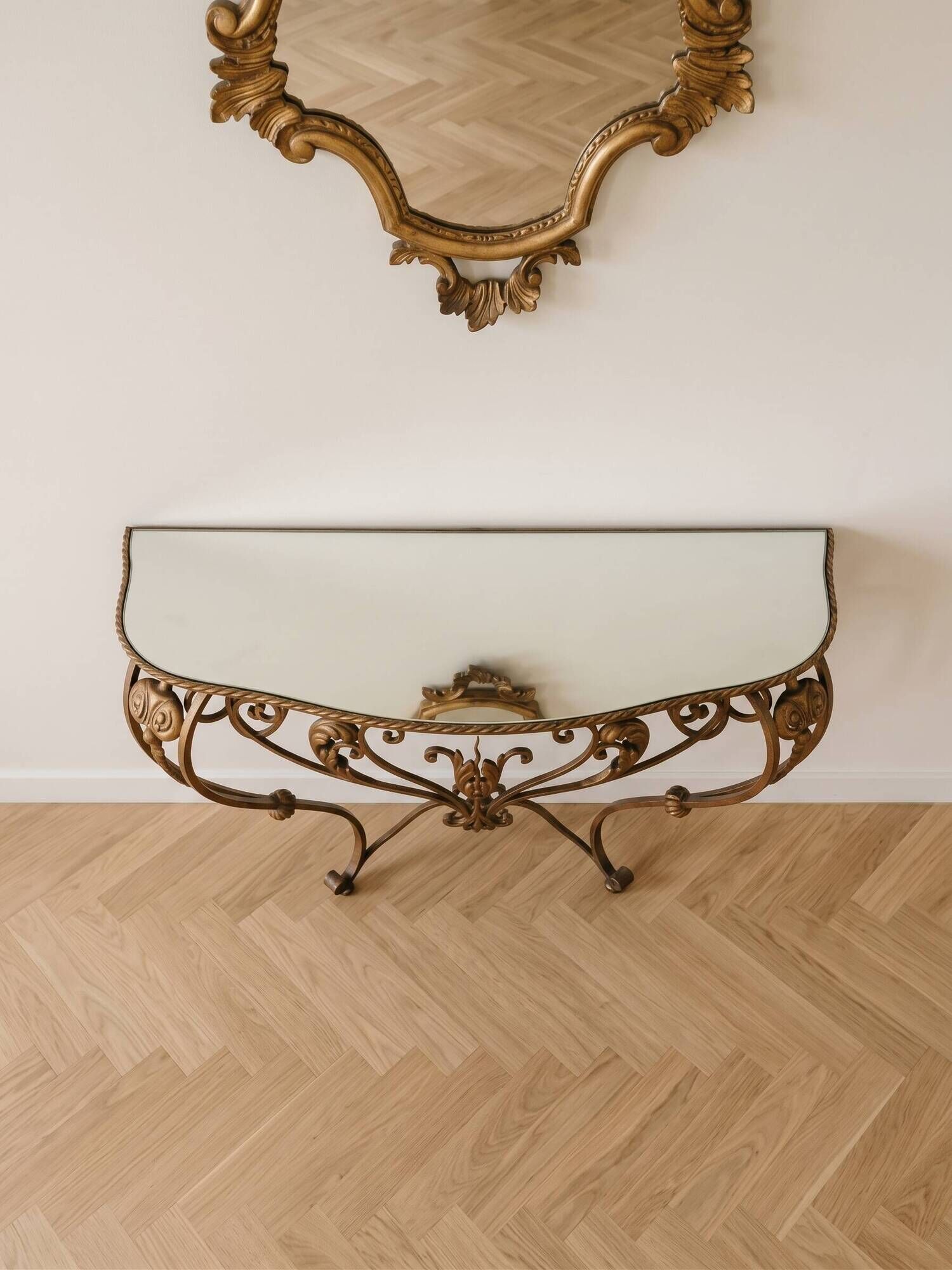 Golden wrought iron console and mirror in rococo style.