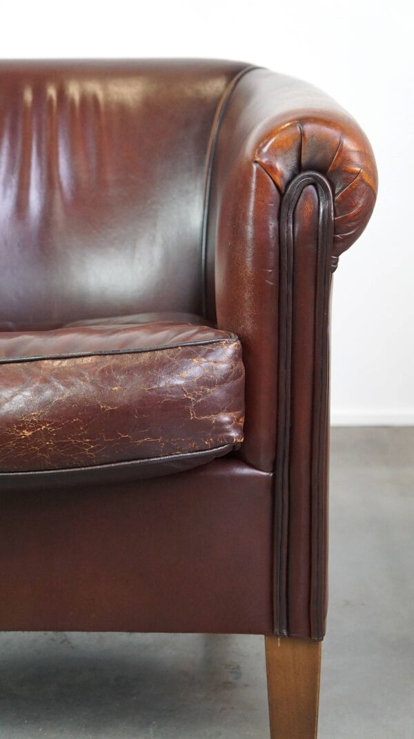 Joli fauteuil club en peau de mouton avec une belle patine