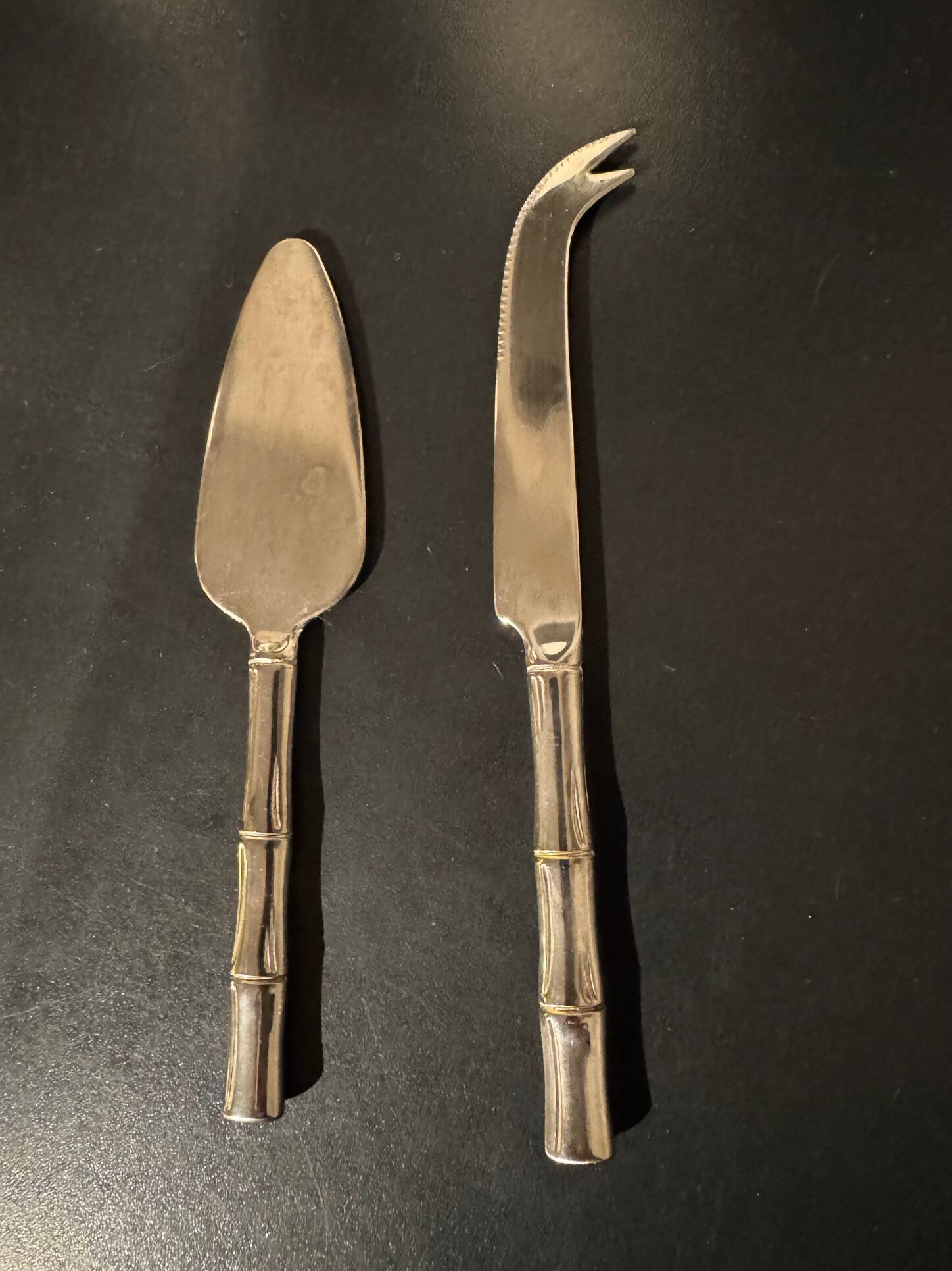 Golden metal cheese cutlery resembling bamboo