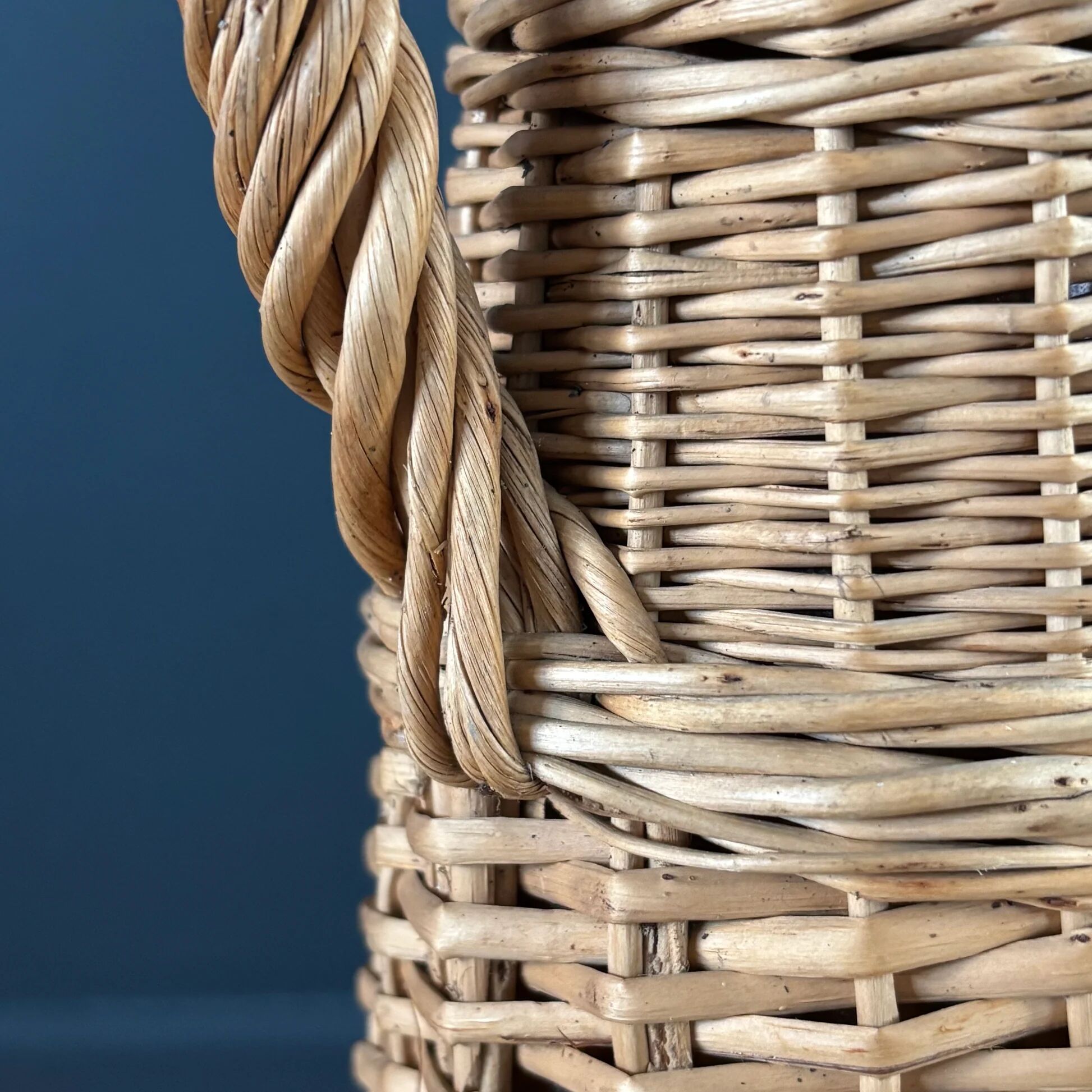 Amber glass bottle in its wicker handle basket.