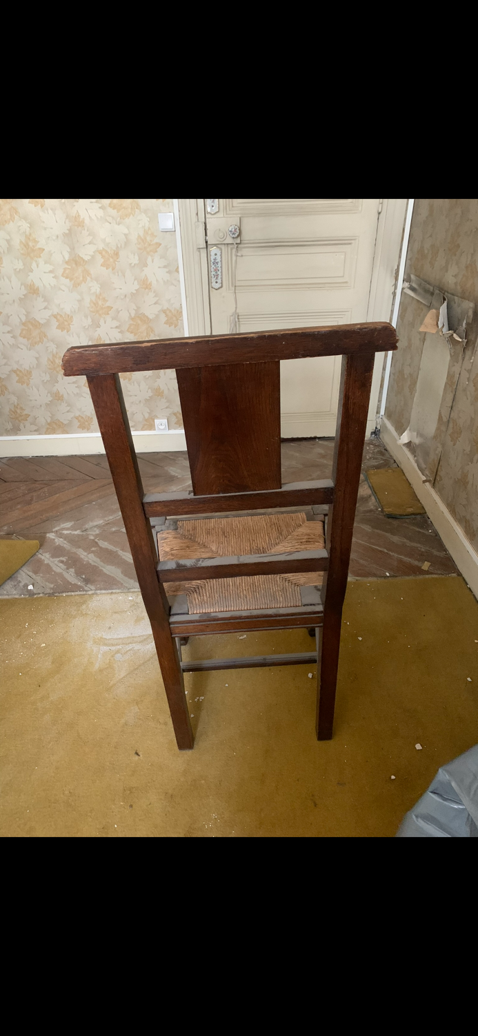Antique carved wooden chairs with straw seats.