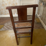 Antique carved wooden chairs with straw seats.