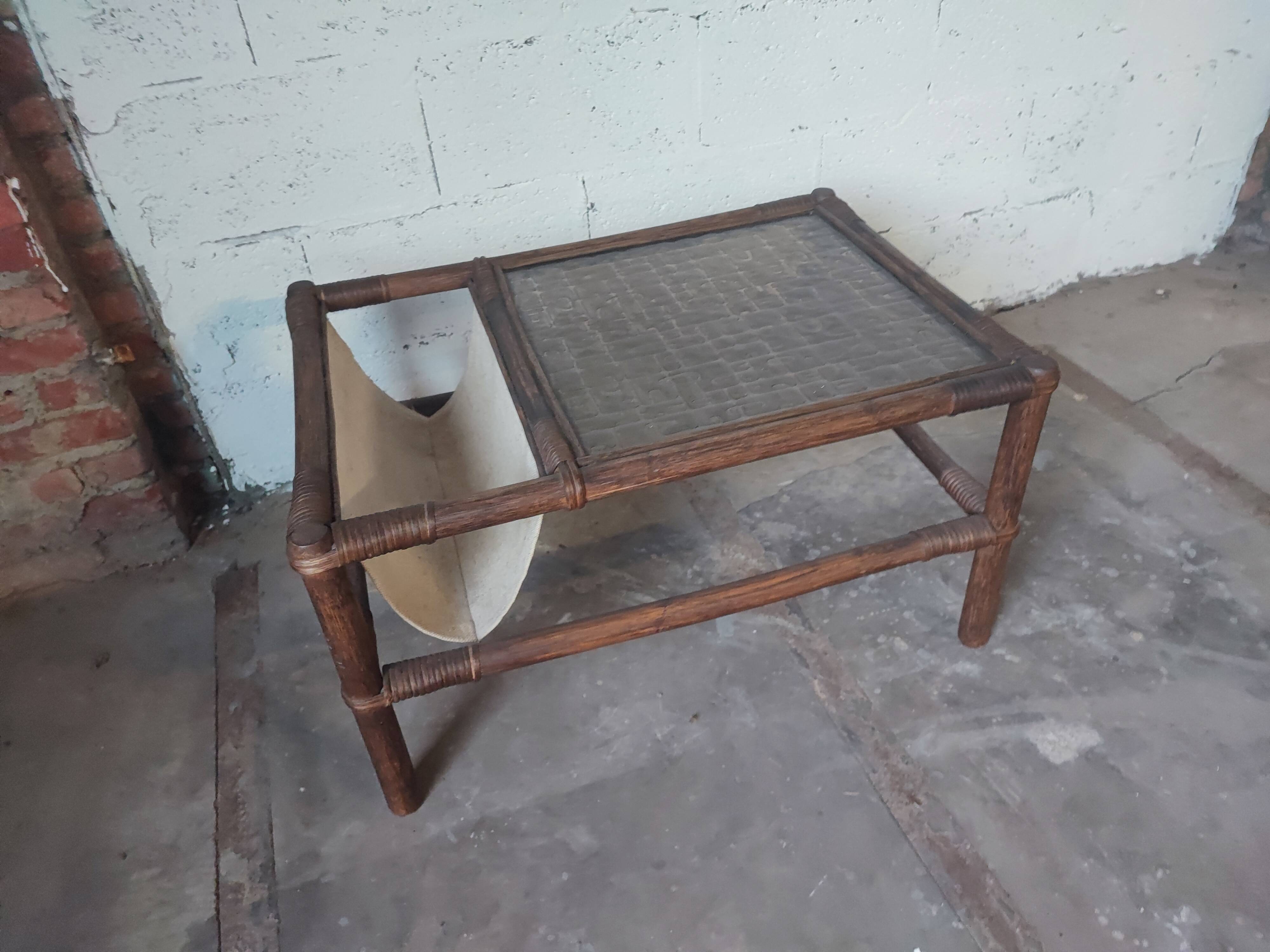 Relaxed armchair in bamboo and rattan with its small side table. Beige linen cushion.