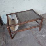 Relaxed armchair in bamboo and rattan with its small side table. Beige linen cushion.
