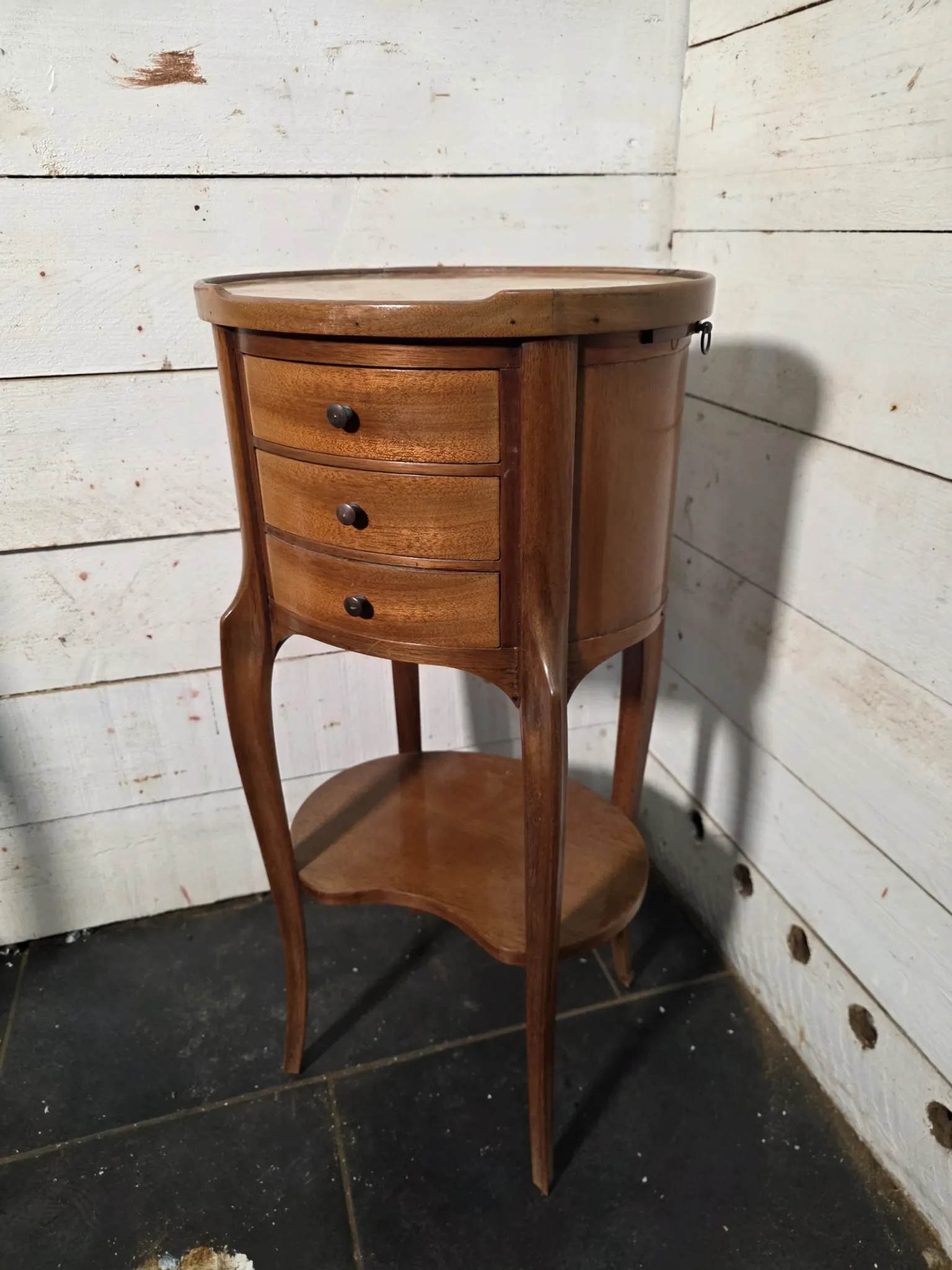 Oval bedside table in Louis XV style made of mahogany.