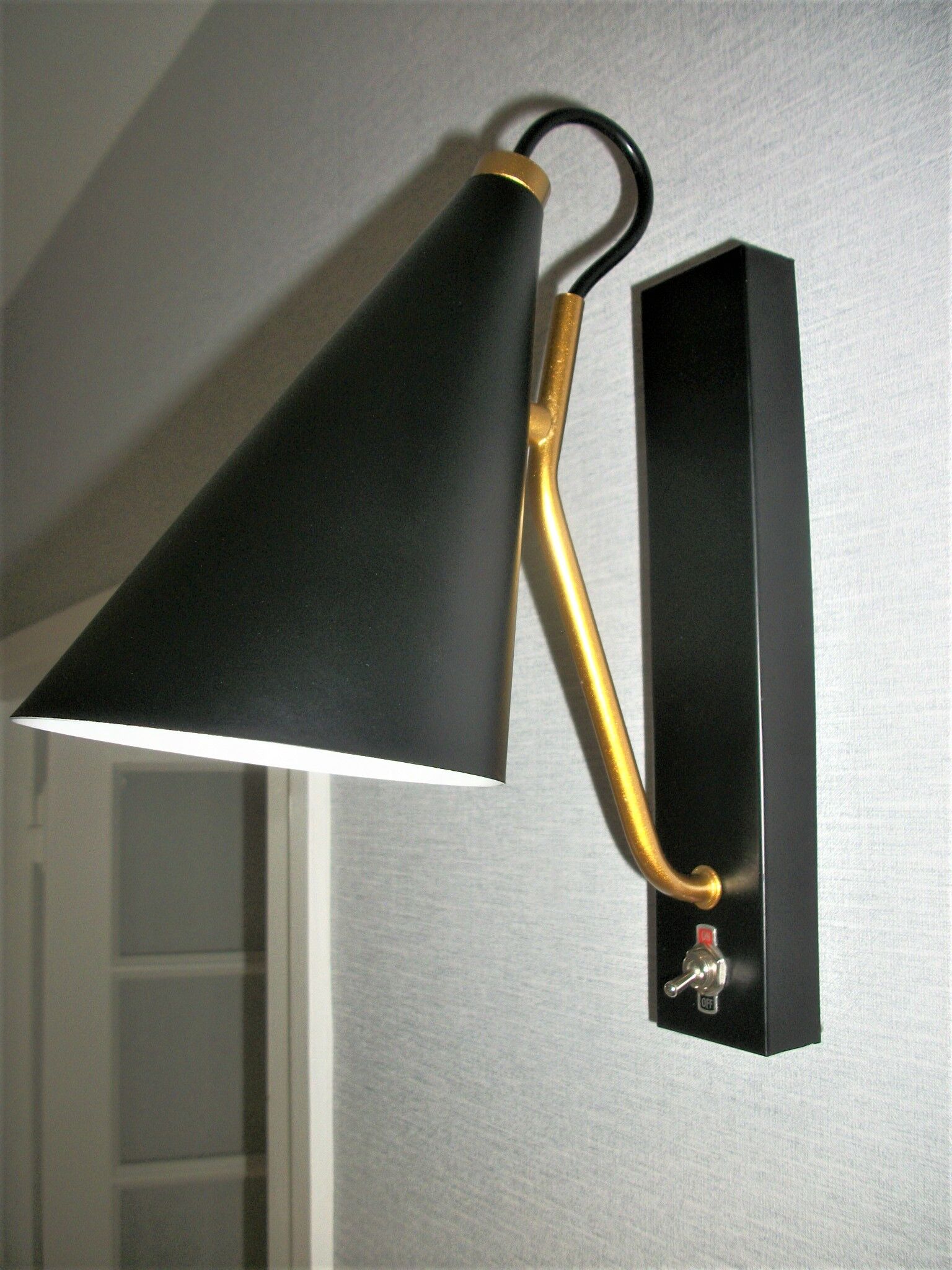 Pair of modernist sconces in black and gold metal