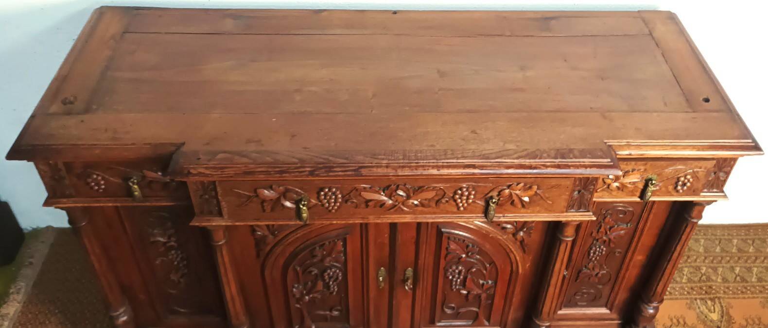 Art Nouveau buffet in carved oak with grapevine cluster decoration.