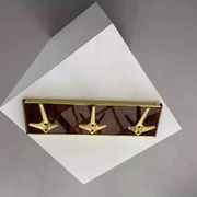 Coat rack or wall hook from the 1950s in wood and brass.