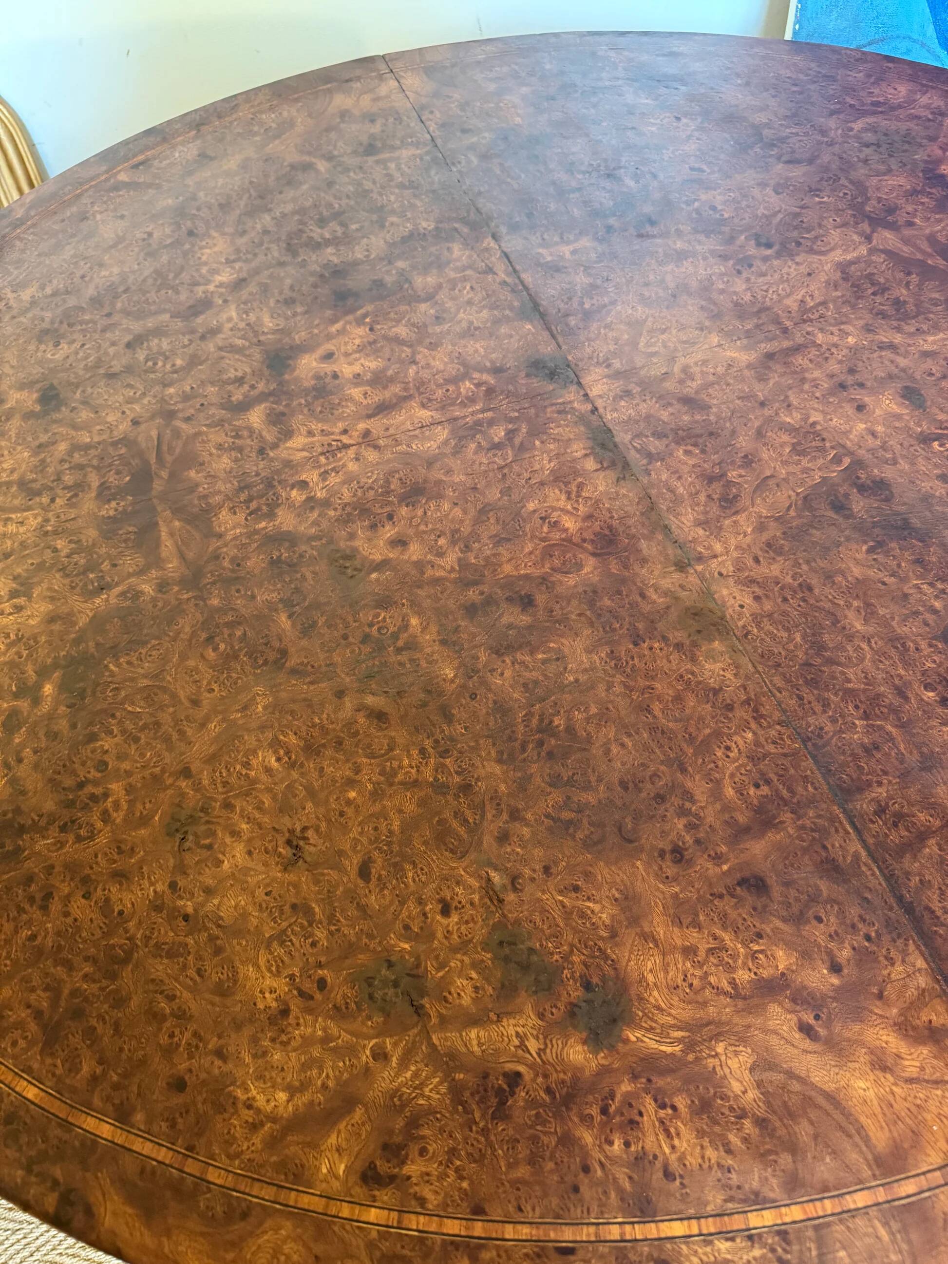 Oval extendable dining table in wood and walnut burl veneer.
