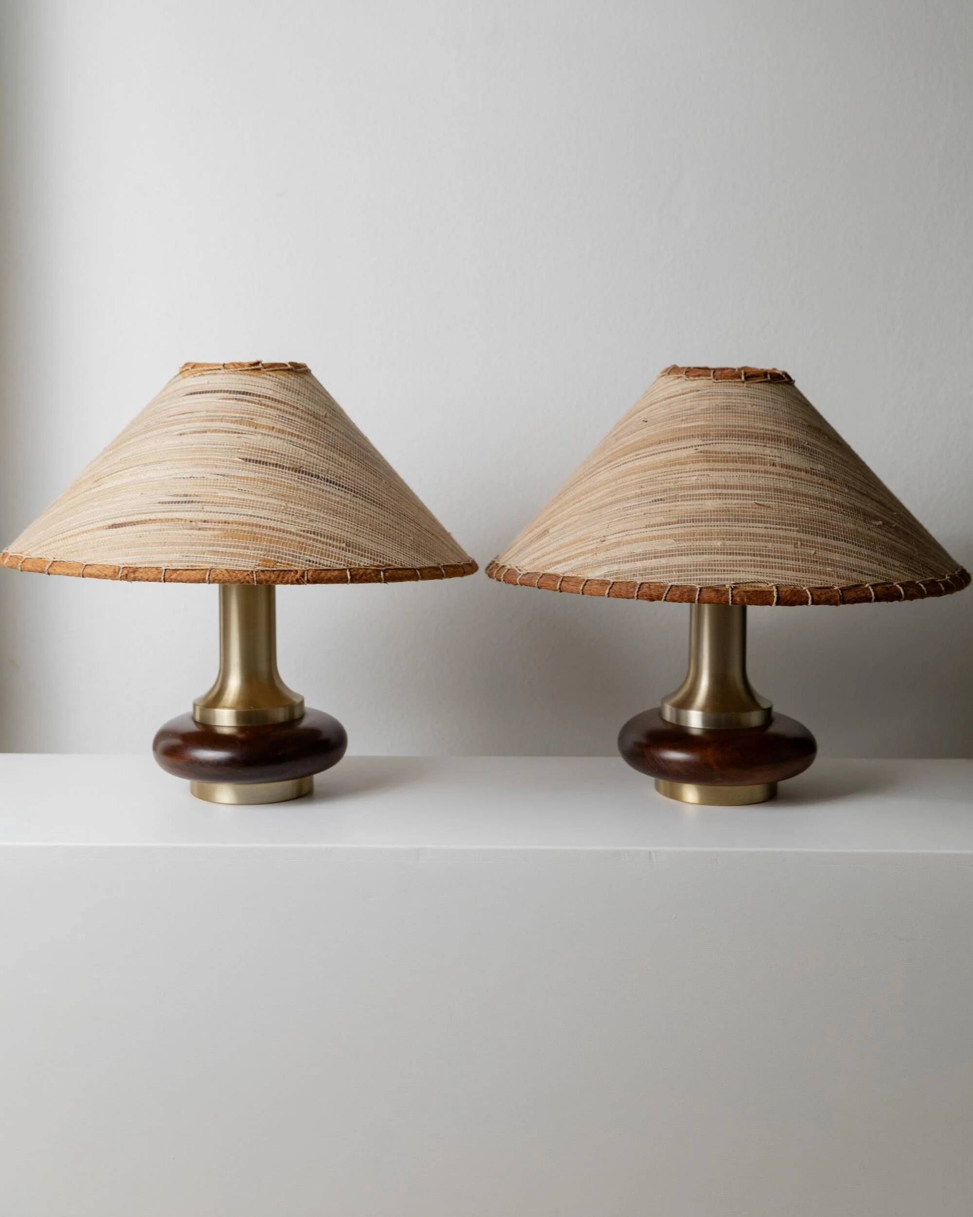 Lot of 2 vintage table lamps from the 1970s, dark wood oval bases with curved brass details, handmade natural fibre lampshades, elegant lighting.