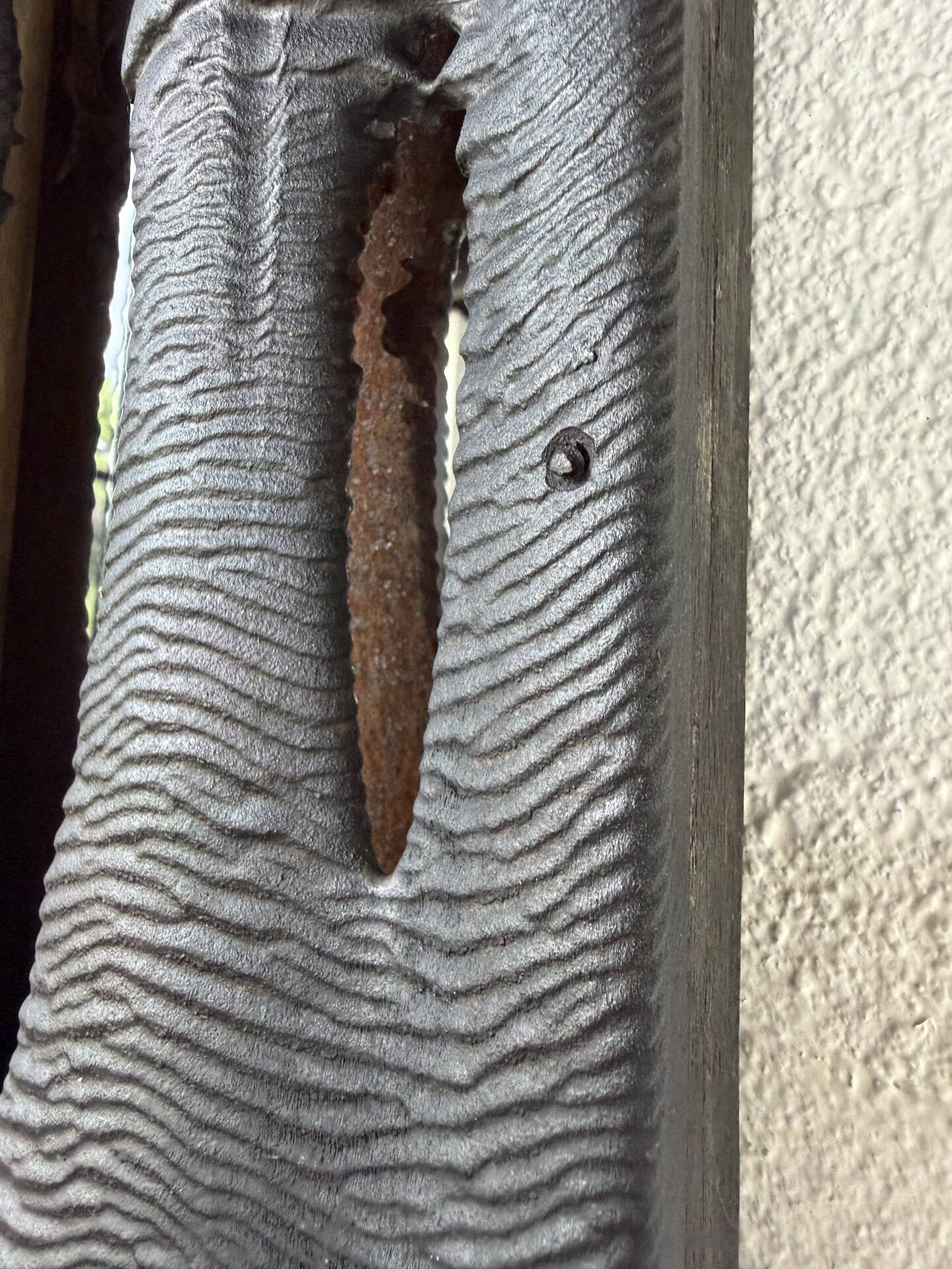Brutalist hammered mirror, free-form, patinated metal.