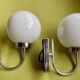 Pair of chrome metal wall lights with white glass globe.