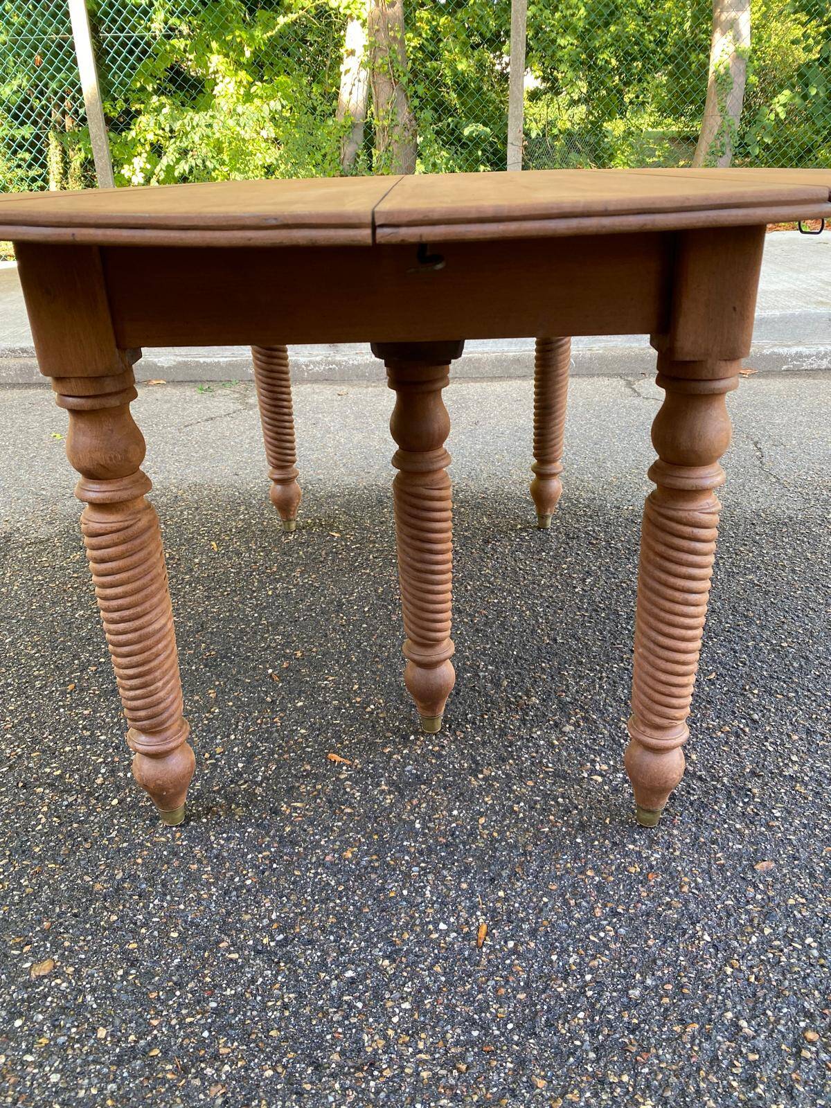Round extendable banquet table stripped in solid mahogany with 4 extensions, 19th century.