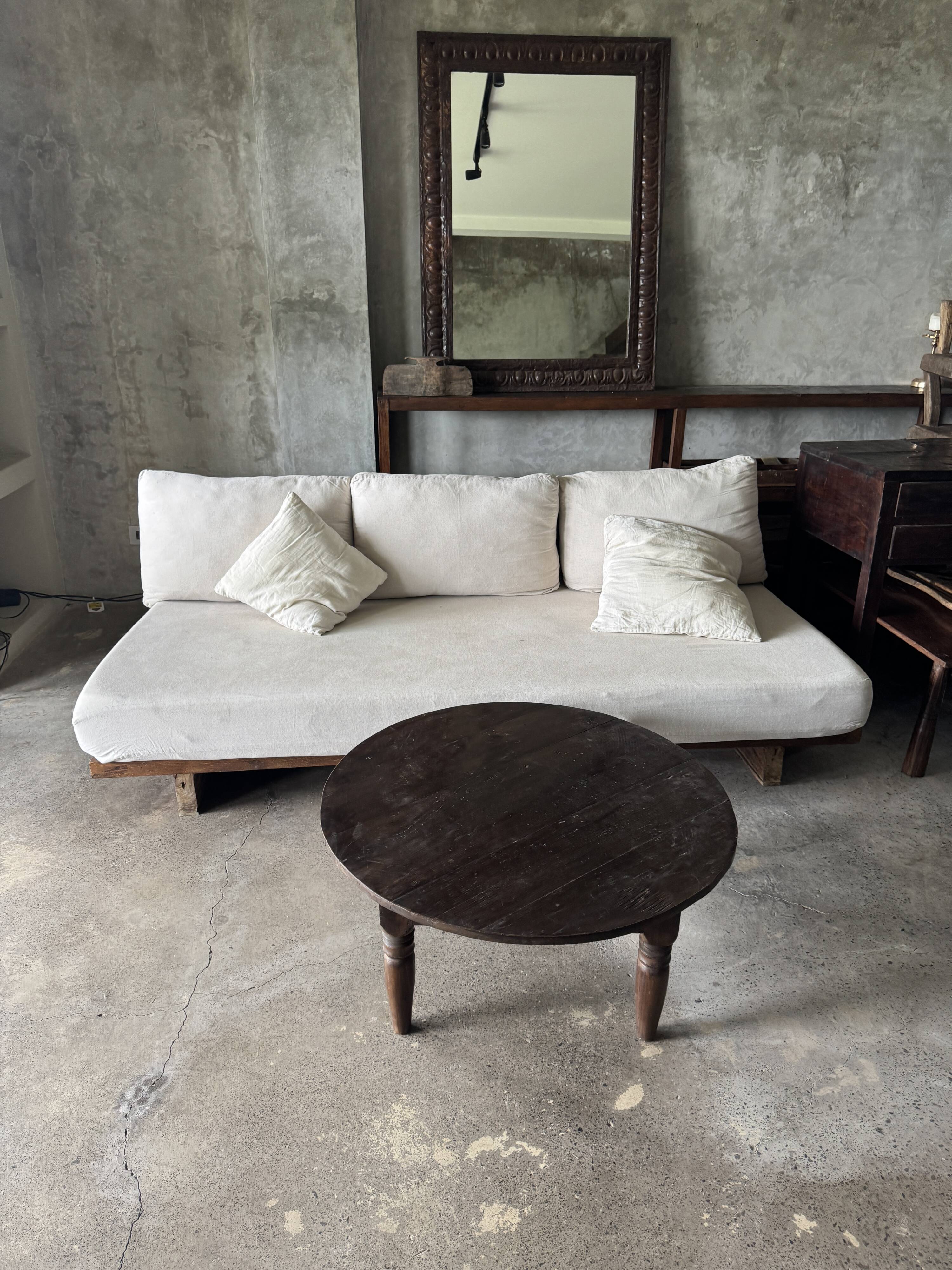 Coffee table, round antique Indonesian teak table with straight legs.