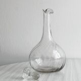 Twisted blown glass carafe with stopper, elegant design.