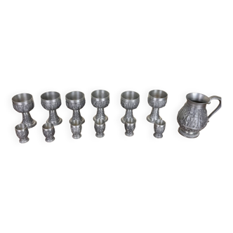 Series of chalices, glasses and jug vintage medieval style in rich pewter decorated with animated scenes