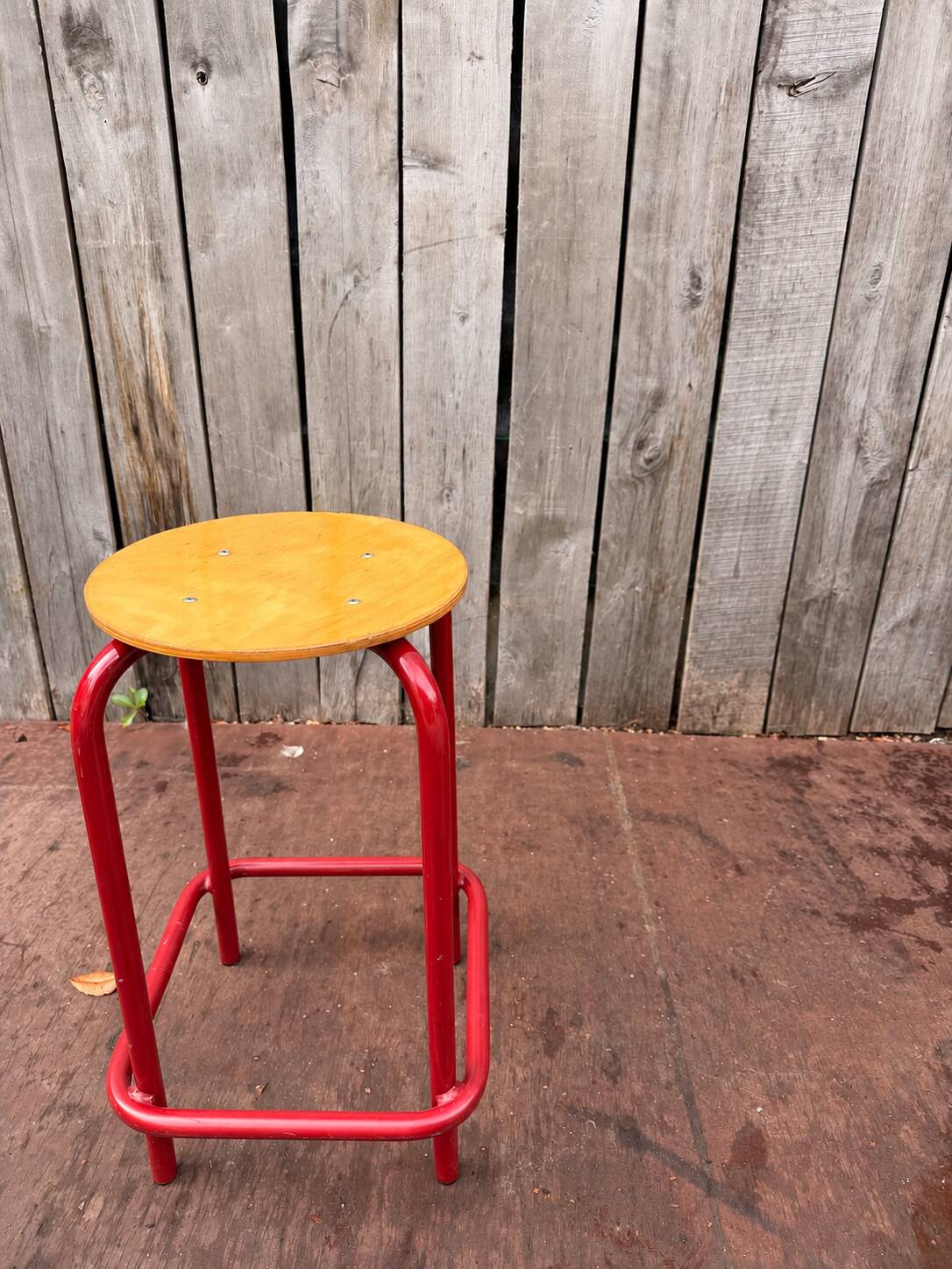 Vintage red industrial stool with a wooden seat, 1960s.