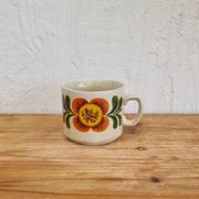 A pair of vintage Weidmann cups with an orange flower motif from the 1970s.