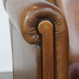 Unique vintage cognac-coloured leather club armchair with black piping