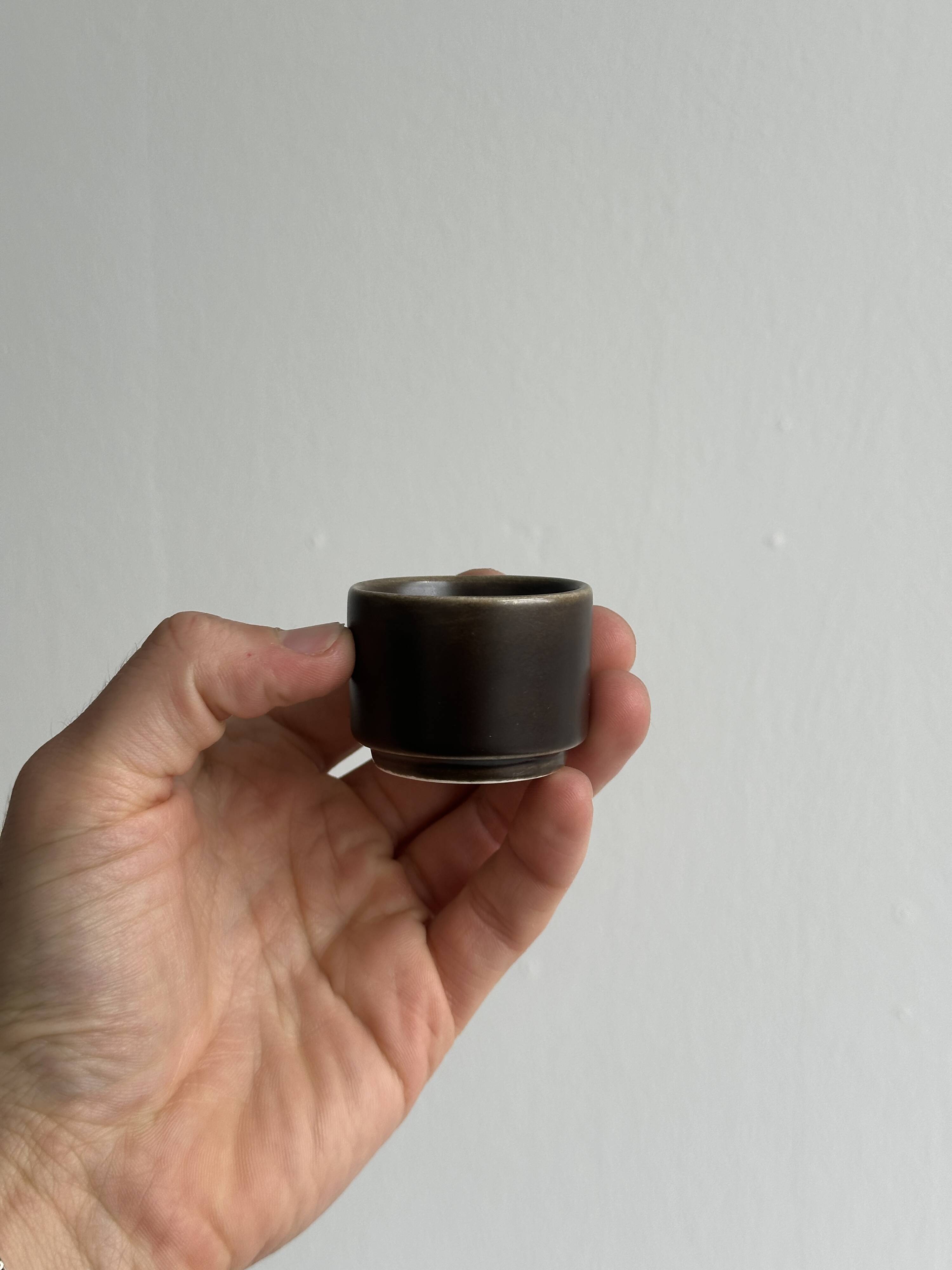 Set of 5 dark brown glazed ceramic egg cups.