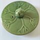 Vintage green teapot with lotus decoration and bamboo handle.