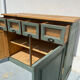 Antique counter cabinet with drawers and label holders – green patina