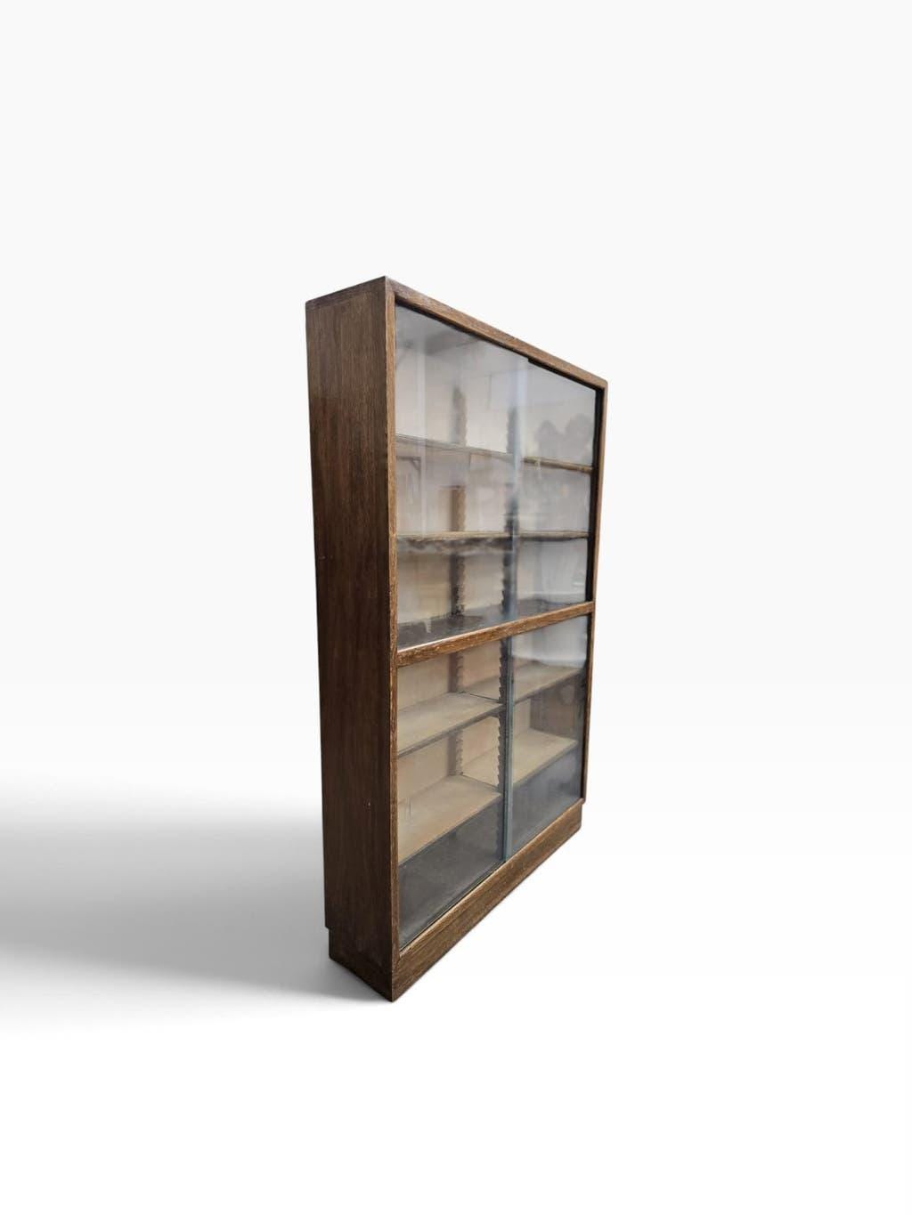 Vintage shallow wooden display shelf with sliding glass doors.