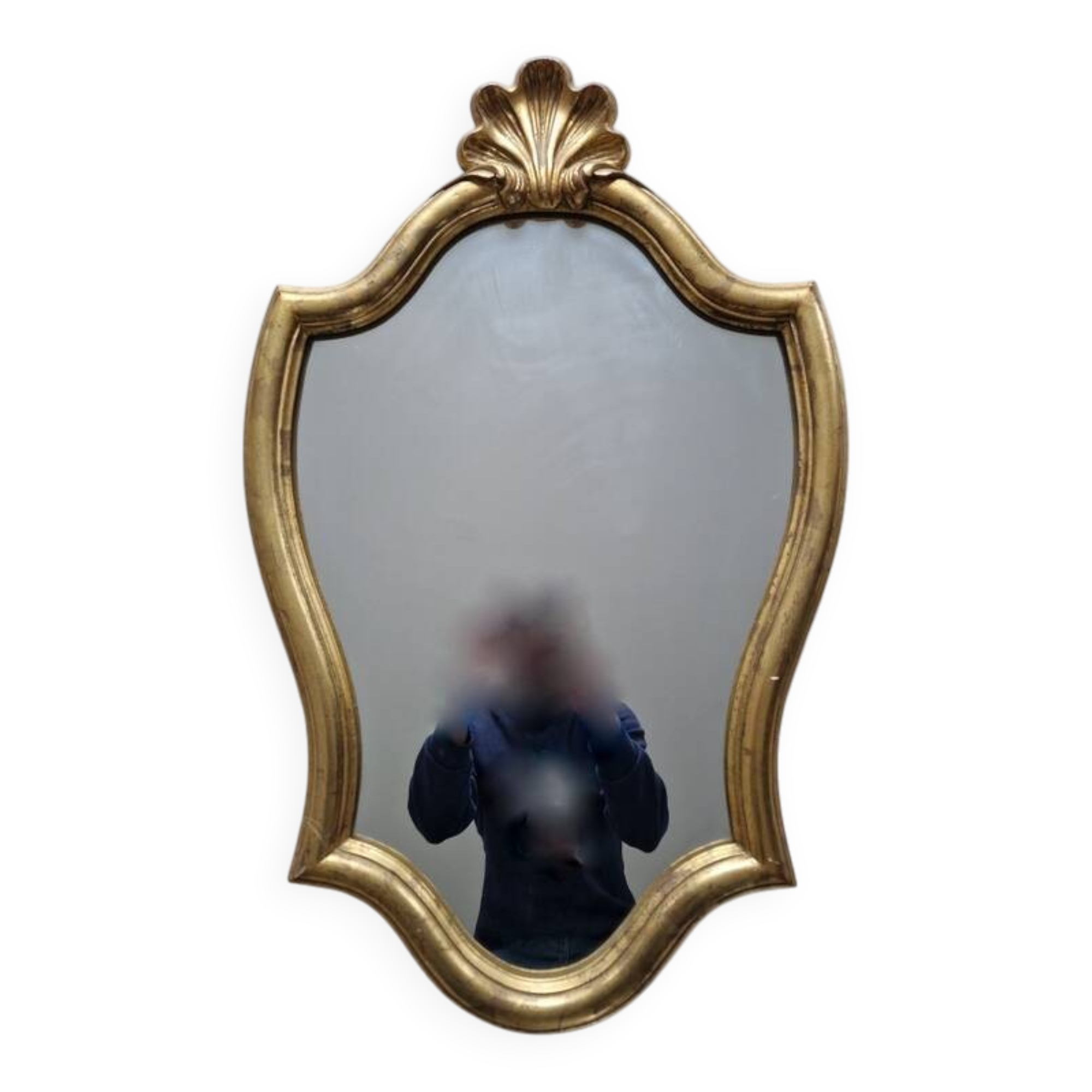 Carved and gilded wooden mirror, the pediment decorated with a shell.