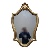 Carved and gilded wooden mirror, the pediment decorated with a shell.